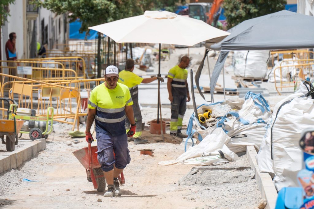 GRAFAND3720. GRANADA, 11/07/2023.- Unos trabajadores se cubren del sol con sombrillas este martes cuando la Agencia Estatal de Meteorología (AEMET) alerta de que continúa la ola de calor en Andalucía y con nivel rojo por riesgo extremo de altas temperaturas de hasta 44 grados en la comarca granadina de la Cuenca del Genil. EFE/Miguel Ángel Molina