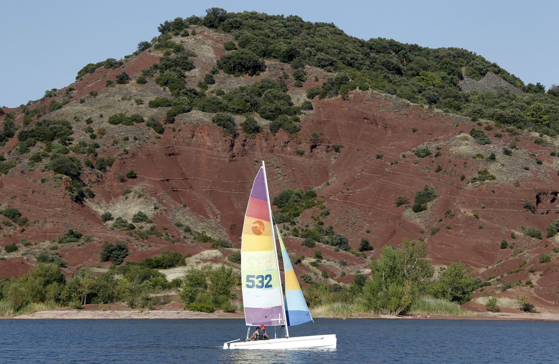 HOR100 OCTON (FRANCIA) 19/08/2011.- Un catamarán navega por el lago Salagou, un día caluroso de verano, cerca de Octon, zona sur de Francia, hoy, viernes 19 de agosto de 2011. Según Méteo-France, la ola de calor que sacude Francia ha provocado temperaturas de más de 40 grados centígrados. EFE/Guillaume Horcajuelo