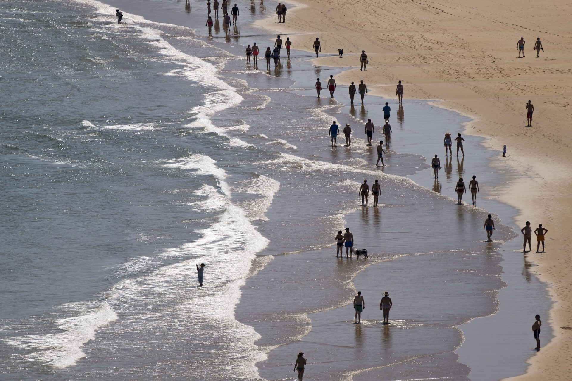 “Personas paseando por la playa de Suances en un día de intenso calor”