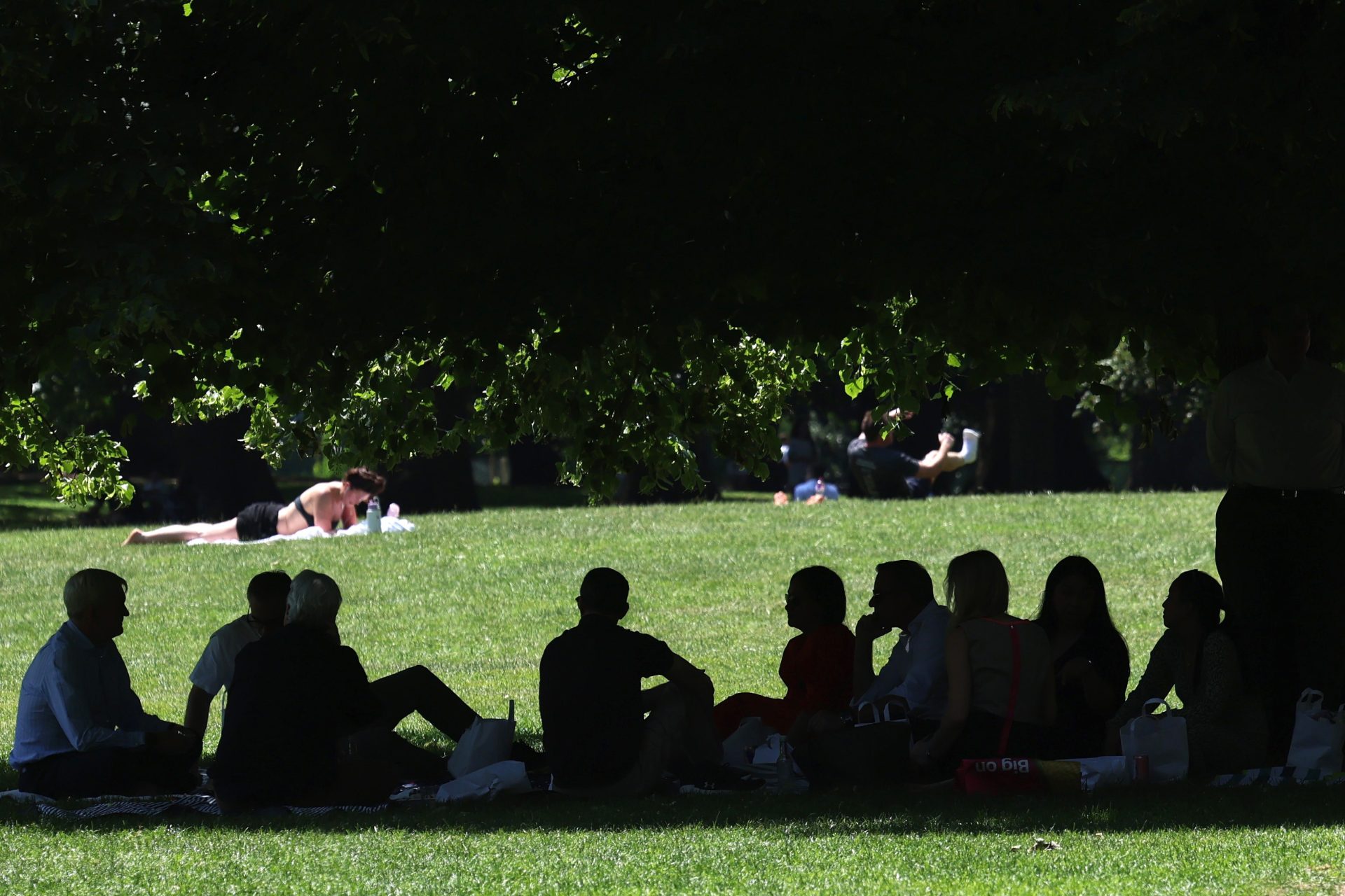 LONDON (United Kingdom), 24/06/2026.- Park goers sit in the shade during a heatwave in London, Britain, 24 June 2026. The UK is bracing for its hottest June day on record, with temperatures forecast to rise above 39 Celsius. The Met Office has issued a red warning for extreme heat for 24 June. (Reino Unido, Londres) EFE/EPA/ANDY RAIN