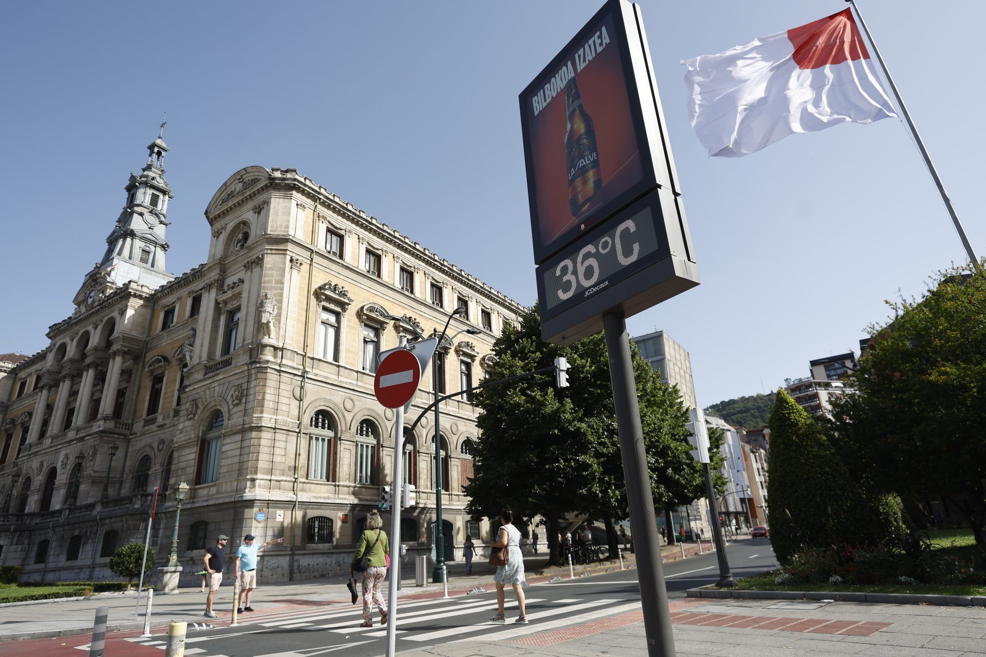 Personas caminan por Bilbao durante una jornada de calor extremo con temperaturas superiores a los 35 grados.