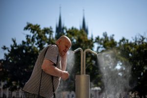 PRAGUE (Czech Republic), 31/07/2026.- A man cools off beneath a misting station in Old Town Square during a hot, sunny day in Prague, Czech Republic, 31 July 2026. Meteorologists forecast temperatures of up to 40 degrees Celsius in some parts of the country amid another wave of extreme heat. (República Checa, Praga) EFE/EPA/MARTIN DIVISEK