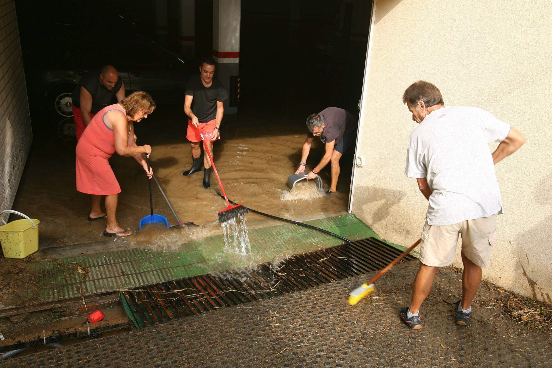 T00. SEGUR DE CALAFELL (TARRAGONA), 22/08/2014.- Vecinos de Segur de Calafell achican agua de un sótano inundado tras las fuertes lluvias registradas de madrugada en diversos puntos de Cataluña. EFE/Jaume Sellart