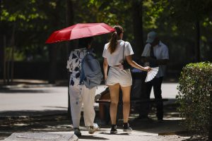 MADRID, 23/06/2026.- Dos mujeres se protegen del calor en el Parque del Retiro, este martes. La primera ola de calor del verano llevará este martes los termómetros hasta los 44 grados en amplias zonas de España, en el día más extremo del episodio, y antes de un ligero alivio térmico previsto a partir del miércoles. EFE/ Marcos Villaoslada