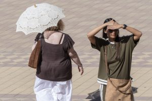 SEVILLA, 02/08/2026.- Varias personas se protegen del sol en Sevilla durante una nueva jornada de calor en la capital hispalense, pese a la bajada de algún grado, los avisos amarillos permanecen en la capital por altas temperaturas. EFE/ David Arjona