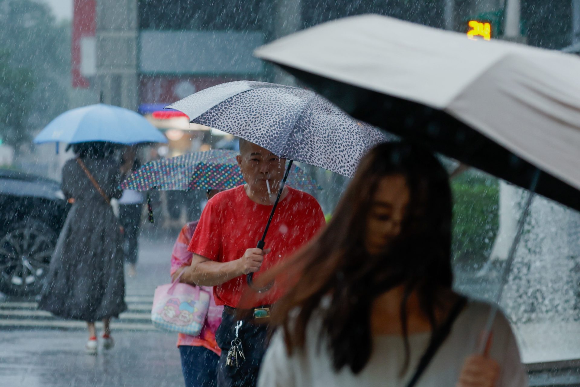 TAIPEI (Taiwan), 08/08/2026.- People cross a street during a downpour of rain brought by Typhoon Dolphin in Taipei, Taiwan, 08 August 2026. The Central Weather Administration reports that Typhoon Dolphin will pass closest to Taiwan between 08 August afternoon and 09 August while heading toward China. A land warning for Taiwan is now considered unlikely, and officials are monitoring the storm's potential impact on the Matsu Islands. (tormenta) EFE/EPA/RITCHIE B. TONGO