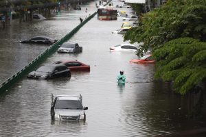 BANGKOK (Thailand), 26/09/2026.- A motorist wades through floodwater as submerged vehicles are abandoned during a downpour on a flooded major street, Phetchaburi Road in Bangkok, Thailand, 26 September 2026. All 50 districts in Bangkok have been declared flood disaster zones following the non-stop heavy downpour caused by a strong low-pressure system combined with seasonal monsoon patterns. (Inundaciones, Tailandia) EFE/EPA/RUNGROJ YONGRIT